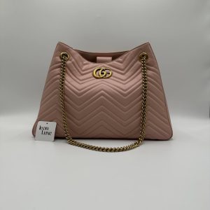 Stylish pink chevron-patterned handbag with gold chain strap and logo detail, perfect for casual or formal occasions.